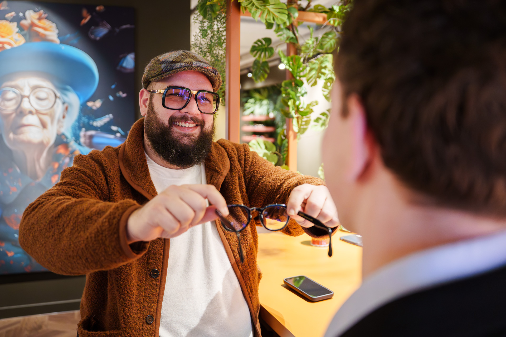 Mitch helpt een klant bij het passen van een bril