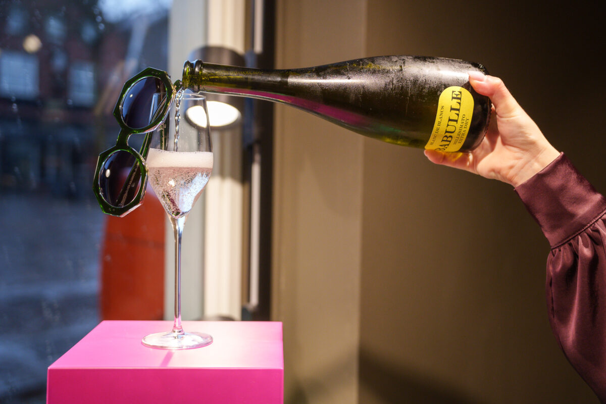Champagne ingeschonken naast een groene zonnebril